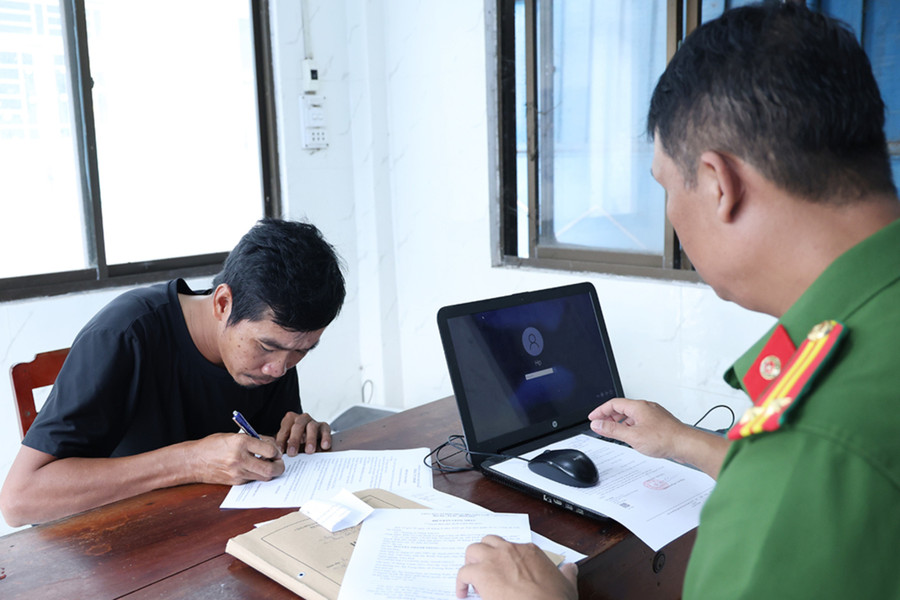 Bị can Nguyễn Thành Trung ký nhận các quyết định và lệnh. Ảnh: Tiến Tầm. cuop-tai-san-2.jpg