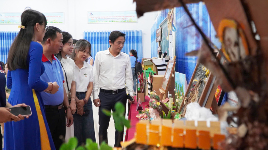 Các đại biểu tham quan khu vực trưng bày các sản phẩm tái chế từ rác thải, giấy vụn. Ảnh: Yến Phương.
