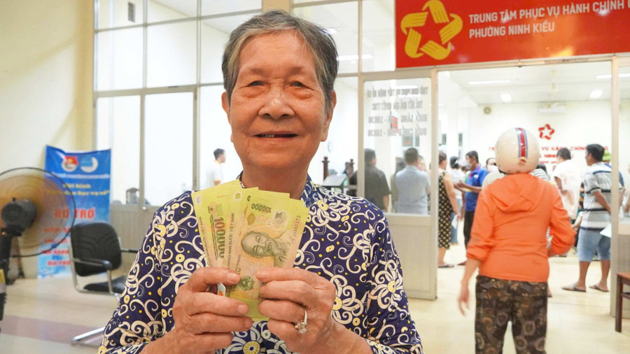 Người dân tại Cần Thơ vui mừng nhận quà Quốc khánh 100.000 đồng. Ảnh: Yến Phương.