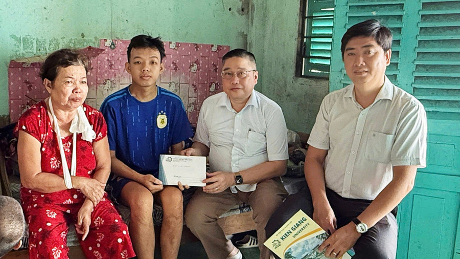TS Nguyễn Hữu Thọ, Bí thư Đảng ủy, Chủ tịch Hội đồng Trường Đại học Kiên Giang trao tiền hỗ trợ sinh viên Tuấn Anh và gia đình.