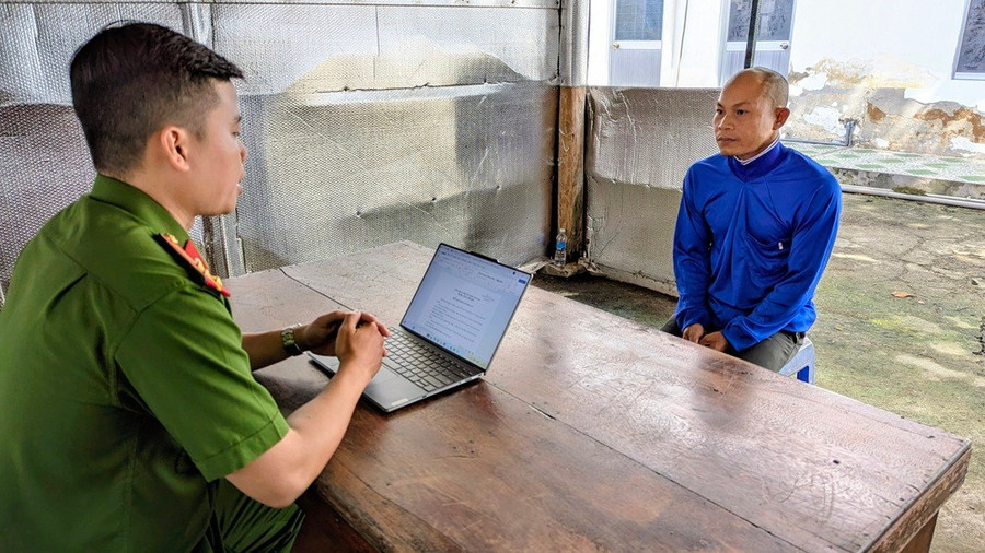 Cán bộ đang ghi lời khai bị can Lê Trí Tâm Anh. Ảnh: Công an An Giang.