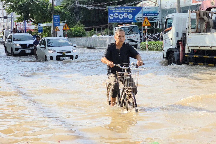 Tình trạng triều cường dâng cao đã khiến từng dòng xe chầm chậm lội qua biển nước, người dân chật vật điều khiển phương tiện qua lại. Người đi xe đạp cũng nhọc nhằn khi qua các đoạn nước sâu. nuoc-ngap-trieu-cuong-2.jpg