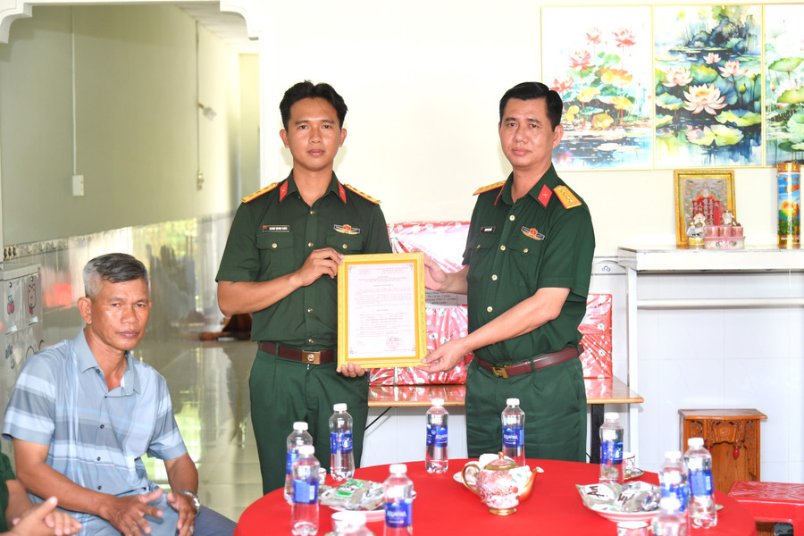 Đại tá Huỳnh Văn Khởi trao Quyết định bàn giao Nhà đồng đội cho gia đình Thượng úy Danh Minh Hoài. Ảnh: Phương Vũ. nha-dong-doi.jpg