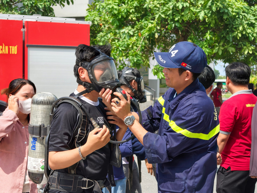 Sinh viên làm quen với việc sử dụng thiết bị thở, mặt nạ phòng độc. Ảnh: Công an Cần Thơ.