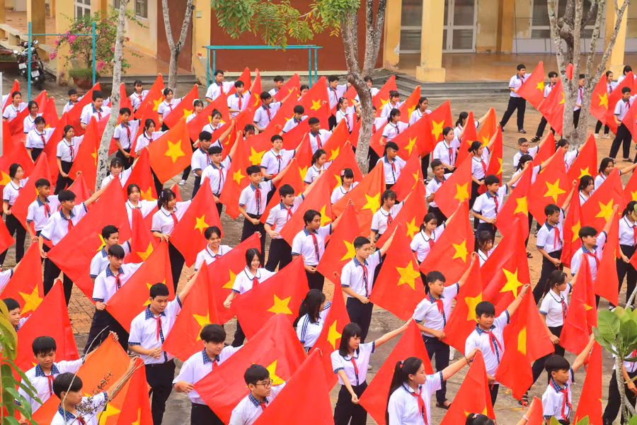 Gần 300 học sinh Trường THCS Thị trấn Cờ Đỏ "nhuộm đỏ" sân trường bằng cờ Tổ quốc.