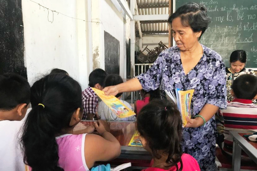 Cô giáo Son phát sách tập, dụng cụ học tập cho các em nhờ sự hỗ trợ của những học trò cũ.