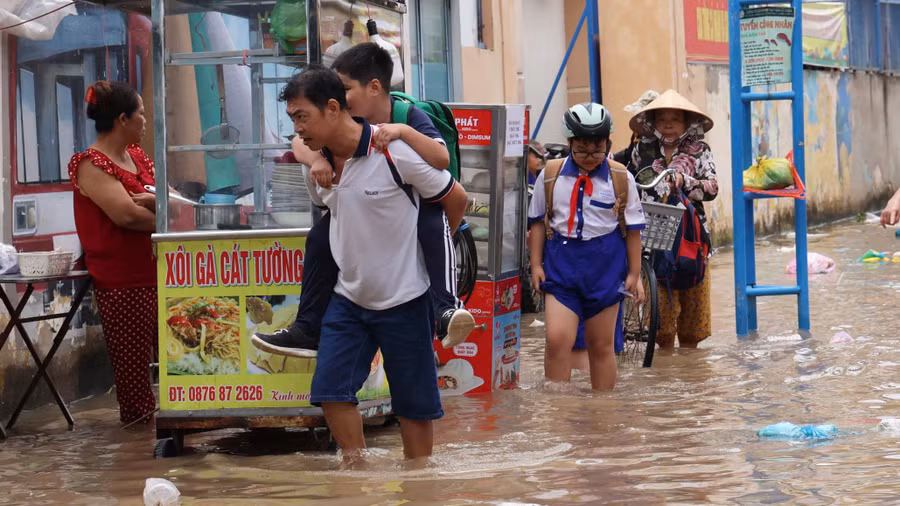 Học sinh và phụ huynh vất vả di chuyển khi triều cường dâng cao.