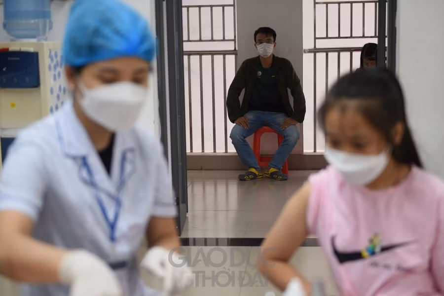 Phụ huynh ngồi bên ngoài theo dõi quá trình tiêm của con em mình.