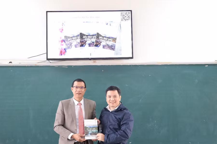 Thầy giáo Lê Chí Thông, Hiệu trưởng Trường THPT Hướng Hóa tiếp nhận sách từ PGS. TS Nguyễn Đông Hải.