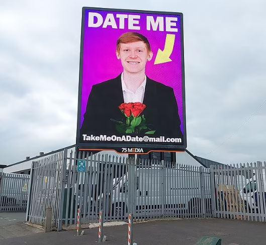 Biển quảng cáo in một tấm ảnh lớn với nụ cười rạng rỡ và bó hoa trên tay. Ảnh: Caters News Agency.