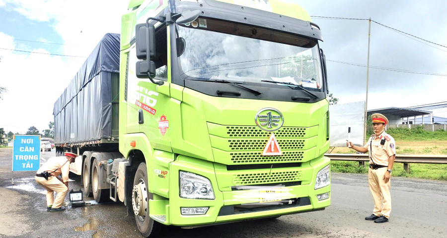 Lực lượng CSGT cân tải trọng xe ô tô chở hàng trên tuyến quốc lộ 14 (ảnh: CTV). Lực lượng CSGT cân tải trọng xe ô tô chở hàng trên tuyến quốc lộ 14 (ảnh: CTV).