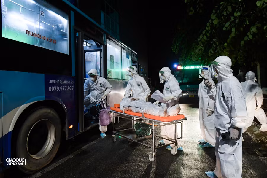 Bệnh nhân được lực lượng y tế tại Bệnh viện Thanh Nhàn đưa xuống cáng để di chuyển vào khu vực cách ly theo đúng quy định.
