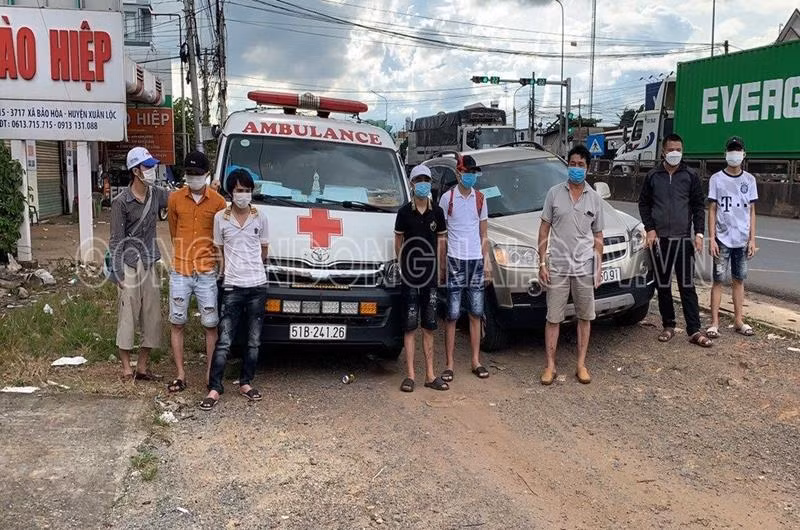 Nhóm 6 người ngồi trên xe cứu thương để di chuyển qua chốt kiểm soát dịch. Ảnh: Công an Đồng Nai.