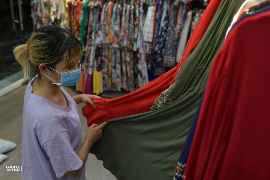 Nhân viên tranh thủ vừa đóng gói hàng do khách đặt online vừa dọn dẹp lại cửa hàng.