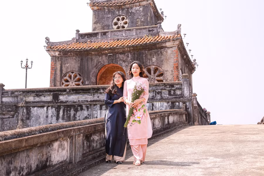 2 nữ sinh viên của trường ĐH Y Dược, ĐH Huế tham quan và chụp hình tại đường đi bộ dọc Kinh thành Huế.
