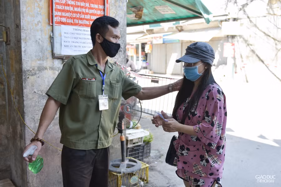 Tất cả người vào chợ đều phải rửa tay sát khuẩn, và đo nhiệt độ.