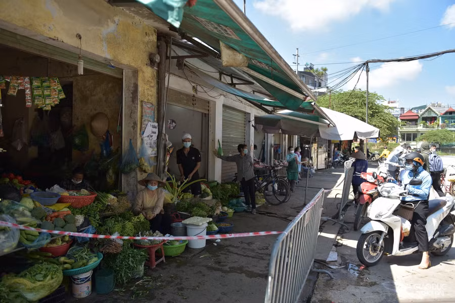 Phía bên ngoài chợ hàng rào chắn cách 2m được lập nên để đảm bảo khoảng cách an toàn từ người bán đến người mua.