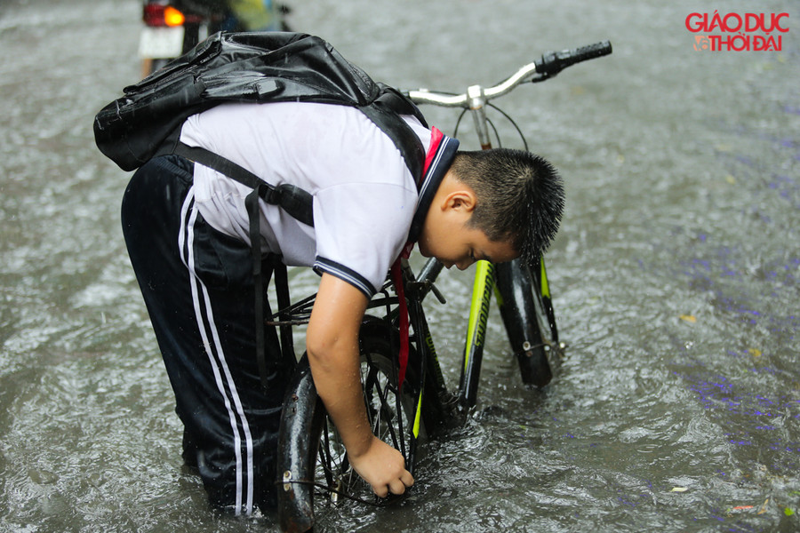 Nhiều học sinh đi học sáng di không chuẩn bị áo mưa nên đã đội mưa, ngập để đi về.