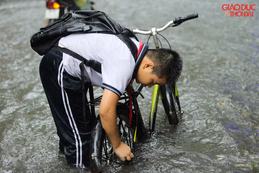Nhiều học sinh đi học sáng di không chuẩn bị áo mưa nên đã đội mưa, ngập để đi về.