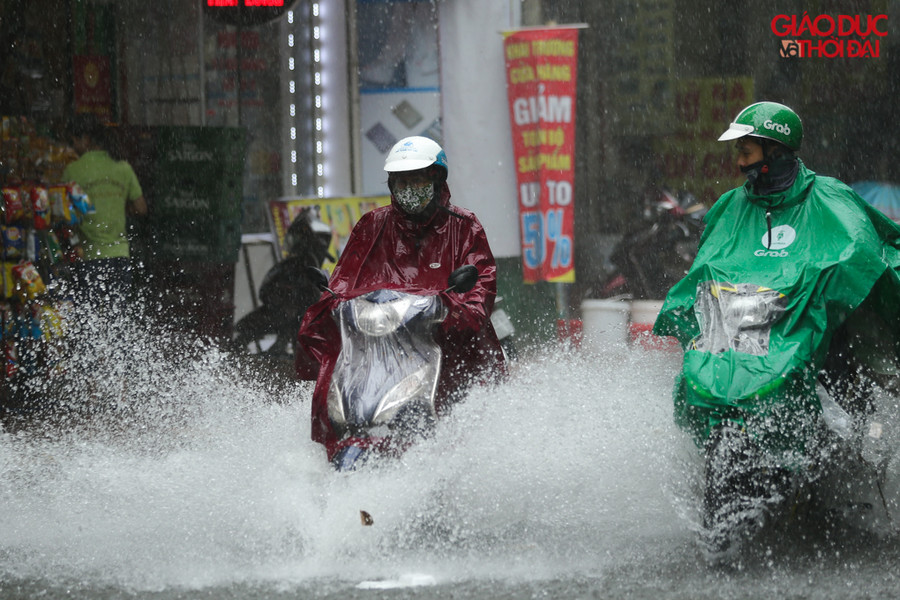 Nước ngập làm các phương tiện đi lại qua tuyến đường Vương Thừa Vũ gặp rất nhiều khó khăn/