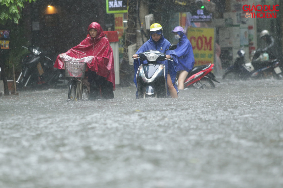 Tại phố Vương Thừa Vũ, nước điểm ngập sâu nhất khoảng 60cm, rất nhiều phương tiện chết máy phải dắt bộ.