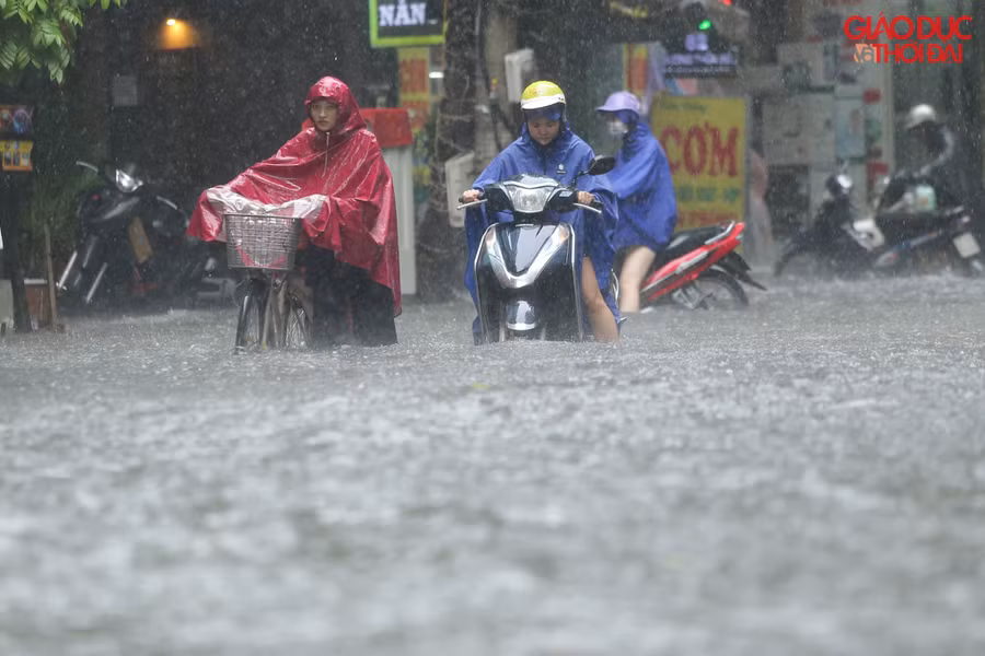 Tại phố Vương Thừa Vũ, nước điểm ngập sâu nhất khoảng 60cm, rất nhiều phương tiện chết máy phải dắt bộ.