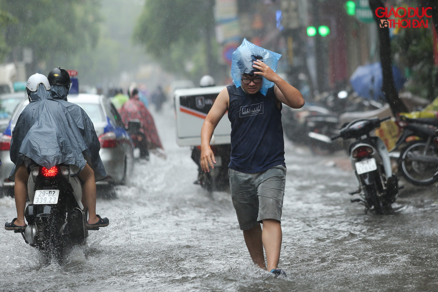 Mưa lớn đúng lúc nghỉ trưa, nhiều người phải bì bõm lội nước để về nhà.