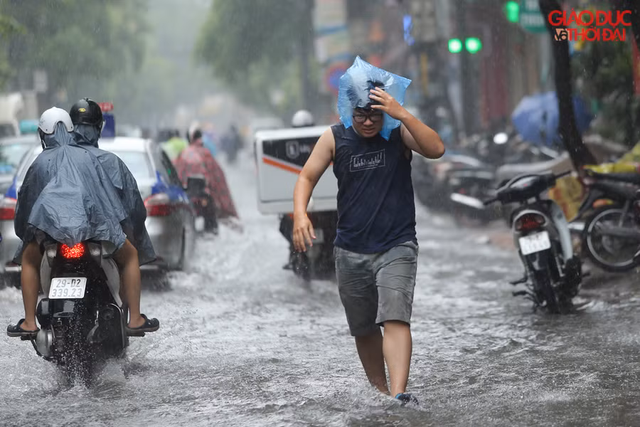 Mưa lớn đúng lúc nghỉ trưa, nhiều người phải bì bõm lội nước để về nhà.
