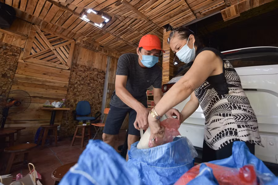 Từ sáng sớm, gia đình anh Lê Việt Dũng ( Nguyễn Khang - Cầu Giấy - Hà Nội) đã tất bật đóng gạo, mỳ tôm vào từng túi nhỏ.