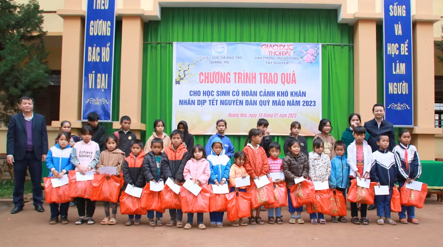 Ông Võ Văn Minh - Phó Giám đốc Sở GD&amp;ĐT Quảng Trị và ông Đào Ngọc Huân - đại diện Công ty Bảo Minh Quảng Trị tặng quà đến học sinh Tiểu học.