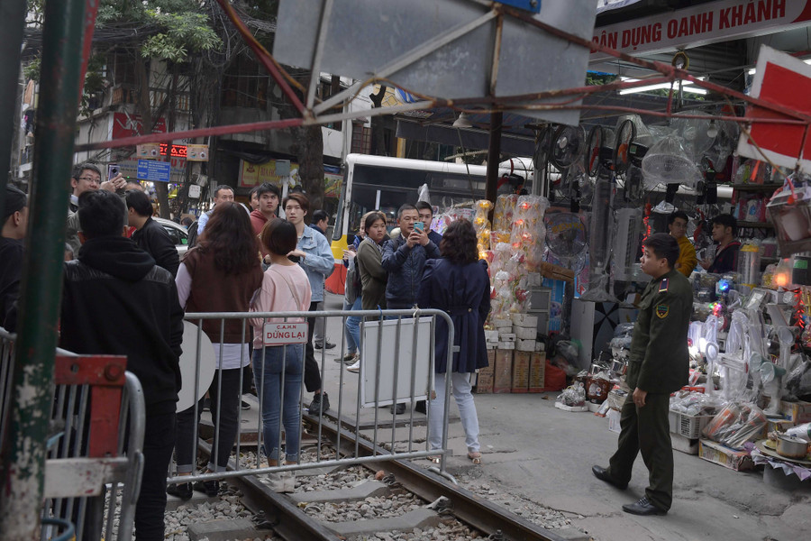 Nhiều du khách đứng phía bên ngoài hàng rào chụp ảnh gây mất an toàn giao thông, nhất là vào lúc cao điểm giao thông.