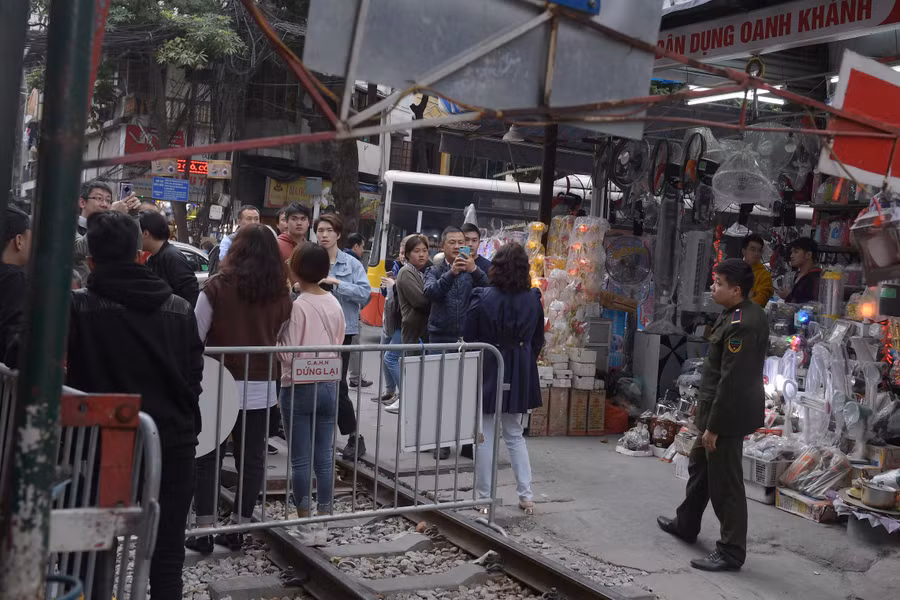 Nhiều du khách đứng phía bên ngoài hàng rào chụp ảnh gây mất an toàn giao thông, nhất là vào lúc cao điểm giao thông.