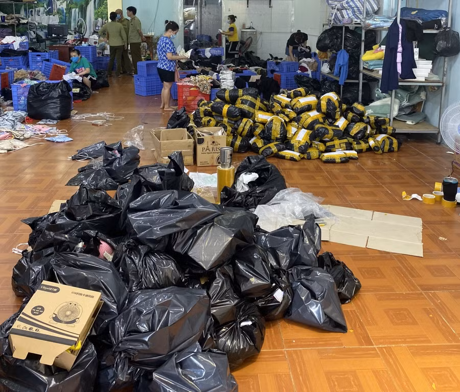 Nhiều hàng hoá trong kho giả mạo thương hiệu nổi tiếng trên thế giới. Ảnh: Tổng Cục Quản lý thị trường.