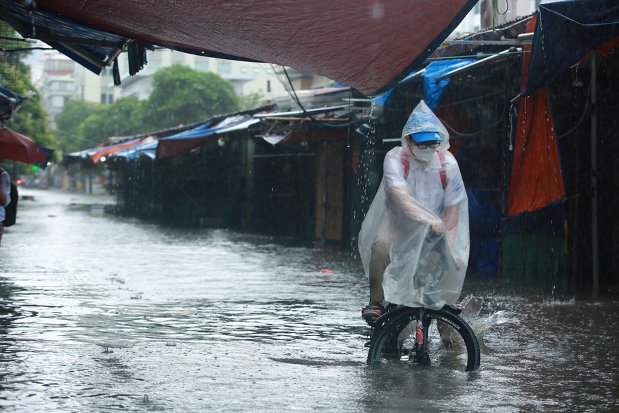 Nhiều người phải đi men theo vỉa hè để tránh các điểm ngập sâu.