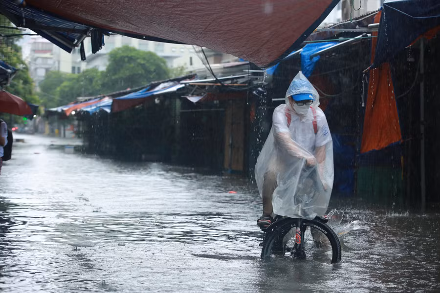 Nhiều người phải đi men theo vỉa hè để tránh các điểm ngập sâu.