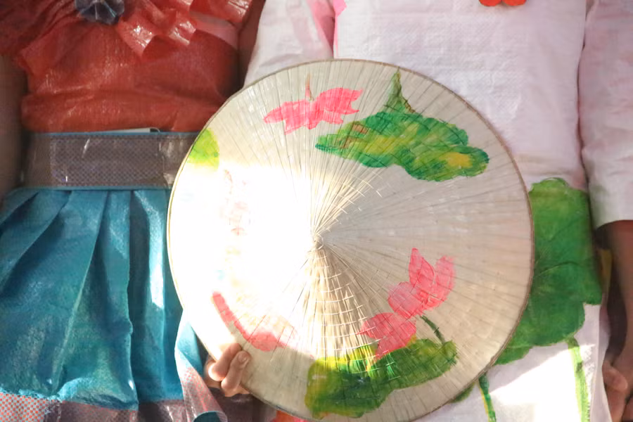 Học sinh khéo léo trang trí chiếc nón lá truyền thống.