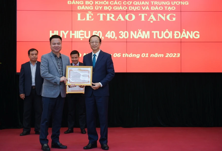 Thay mặt Đảng bộ Báo Giáo dục & Thời đại, đồng chí Triệu Ngọc Lâm – Bí thư Đảng uỷ Báo (bên trái) nhận Giấy khen của Đảng ủy Bộ GD&ĐT do Thứ trưởng Phạm Ngọc Thưởng - Bí thư Đảng ủy Bộ trao tặng.