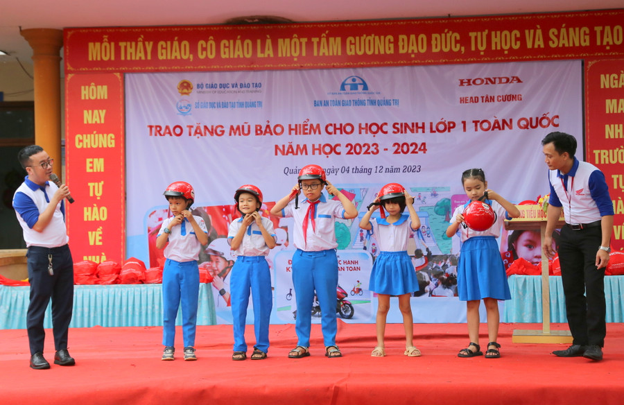 Học sinh được hướng dẫn đội mũ bảo hiểm đúng cách. Học sinh được hướng dẫn đội mũ bảo hiểm đúng cách.