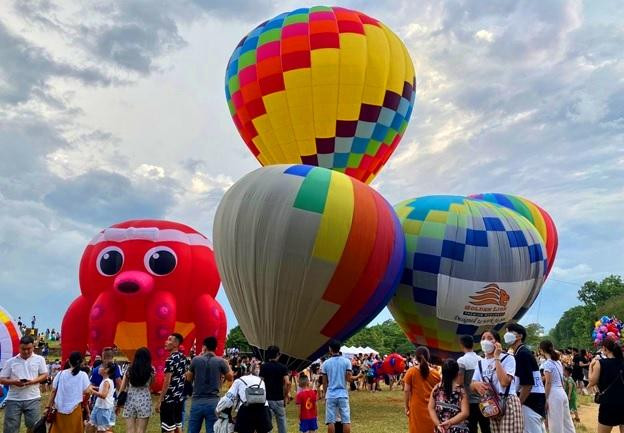 Nhiều khinh khí cầu với nhiều màu sắc và hình dáng khác nhau tại địa điểm bay.