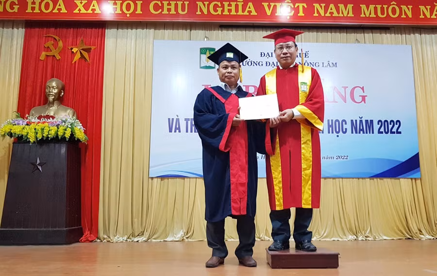 Hiệu trưởng Trần Thanh Đức (phải) trao bằng tốt nghiệp cho các sinh viên.