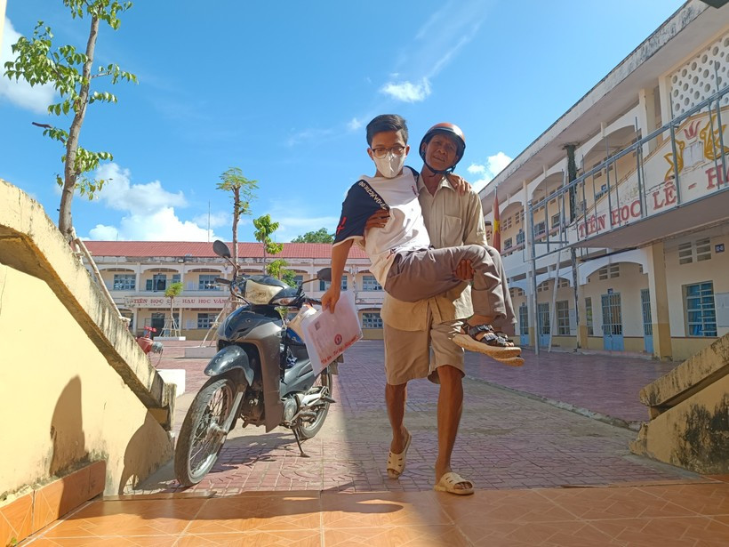 Bố đưa con tật nguyền đi thi.