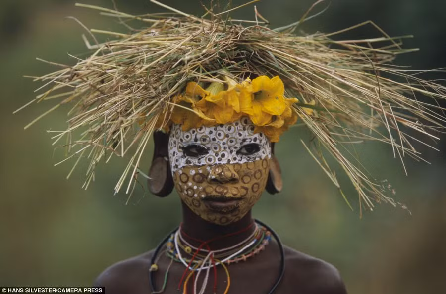 Illustrated: The book highlights the ways of the Omo tribes who live close to nature with their painted faces, scarified bodies and extravagant headdresses with plants and feathers cleverly combined Read more: http://www.dailymail.co.uk/news/article-2294456/Painted-faces-scarred-bodies-wooden-guns-extravagant-headdresses-Amazing-photographs-reveal-lost-world-Omo-tribes-Ethiopia.html#ixzz2Nn05vspu Follow us: @MailOnline on Twitter | DailyMail on Facebook