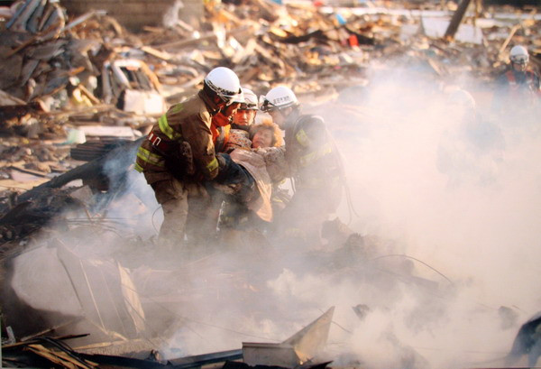 Một nạn nhân đang được lính cứu hỏa giải cứu ra khỏi thị trấn đổ nát tại quận Yuriage, thành phố Natori, tỉnh Miyagi