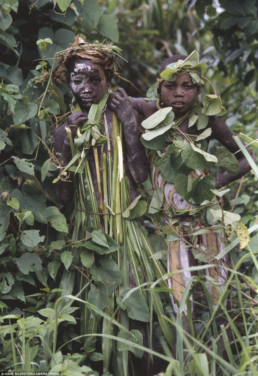 At play: These two children both wear headdresses and clothing made from plants, as well as having their bodies painted Read more: http://www.dailymail.co.uk/news/article-2294456/Painted-faces-scarred-bodies-wooden-guns-extravagant-headdresses-Amazing-photographs-reveal-lost-world-Omo-tribes-Ethiopia.html#ixzz2Nn0cxf4p Follow us: @MailOnline on Twitter | DailyMail on Facebook
