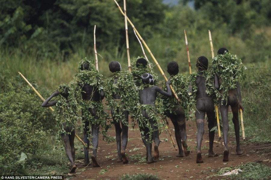 Sharp shooter: A young boy plays with a wooden gun. Although the tribes’ rustic lifestyles are far removed from modern towns and cities influences have crept in Read more: http://www.dailymail.co.uk/news/article-2294456/Painted-faces-scarred-bodies-wooden-guns-extravagant-headdresses-Amazing-photographs-reveal-lost-world-Omo-tribes-Ethiopia.html#ixzz2Nn74RpeC Follow us: @MailOnline on Twitter | DailyMail on Facebook