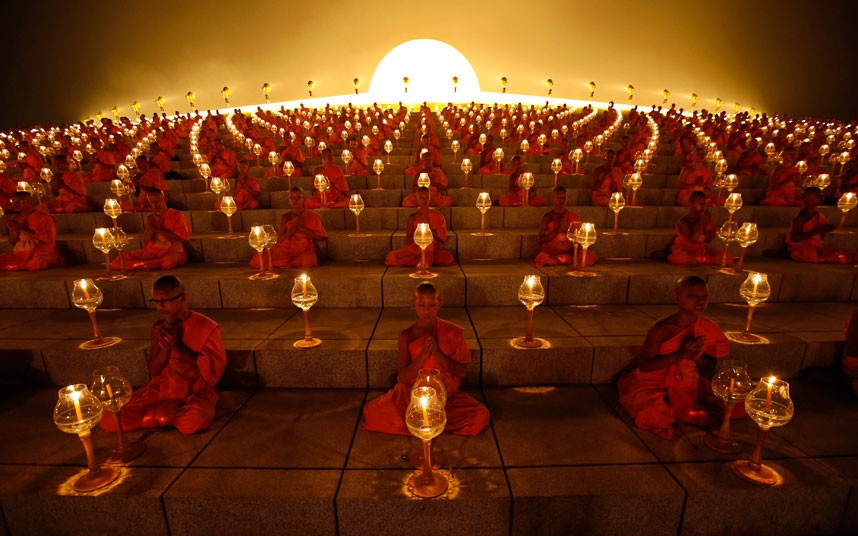 Những hình ảnh ấn tượng trong tuần ảnh 6 Thousands of Thai Buddhist monks chant during a lantern lighting to celebrate Makha Bucha day at Dhammakaya Temple in Pathum Thani province, on the outskirts of Bangkok. Makha Bucha held on the full moon night of the third lunar month and marks the day that Lord Buddha gave the first sermon on the essence of Buddhism to his ordained 1,250 disciples.