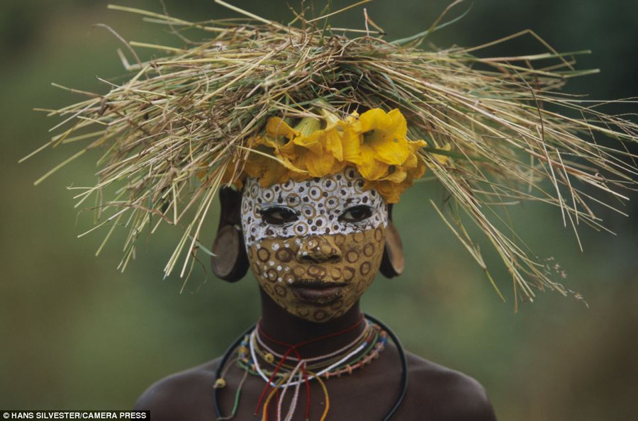 Illustrated: The book highlights the ways of the Omo tribes who live close to nature with their painted faces, scarified bodies and extravagant headdresses with plants and feathers cleverly combined Read more: http://www.dailymail.co.uk/news/article-2294456/Painted-faces-scarred-bodies-wooden-guns-extravagant-headdresses-Amazing-photographs-reveal-lost-world-Omo-tribes-Ethiopia.html#ixzz2Nn05vspu Follow us: @MailOnline on Twitter | DailyMail on Facebook