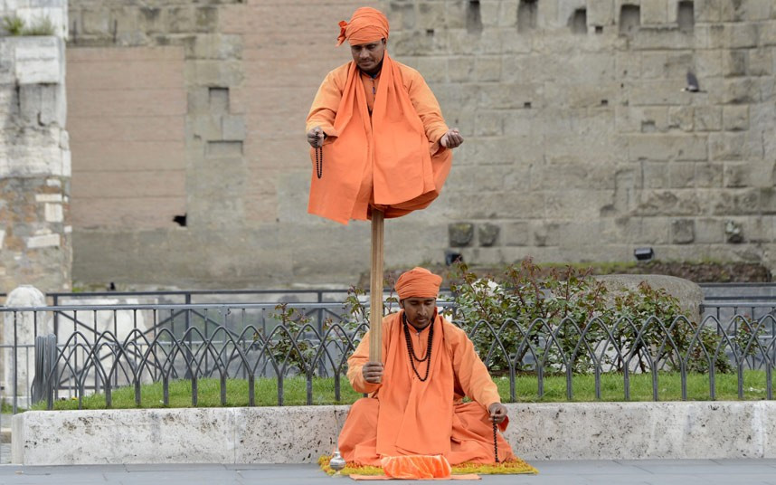Street artists baffle passersby with their gravity defying act on a street in Rome
