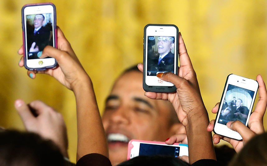 Những hình ảnh ấn tượng trong tuần ảnh 3 Attendees photograph US President Barack Obama with their mobile phones during a Women’s History Month reception at the White House in Washington