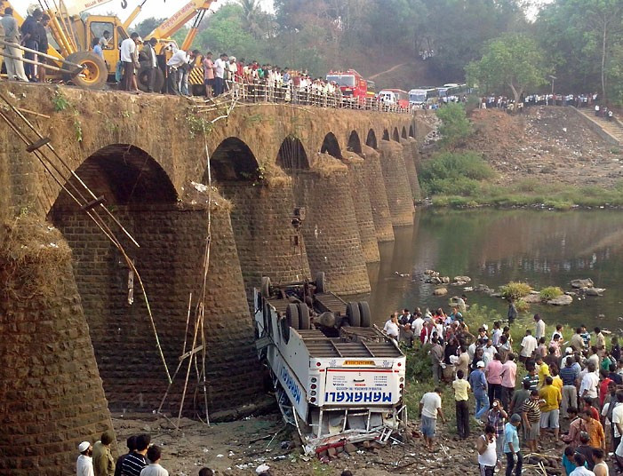 Những hình ảnh ấn tượng trong tuần ảnh 7 Rescuers and bystanders look at the wreckage of a passenger bus after it fell from a bridge in Ratnagiri district in the western Indian state of Maharashtra. At least 37 people were killed and 15 others injured after the bus fell into the Jagbudi River.